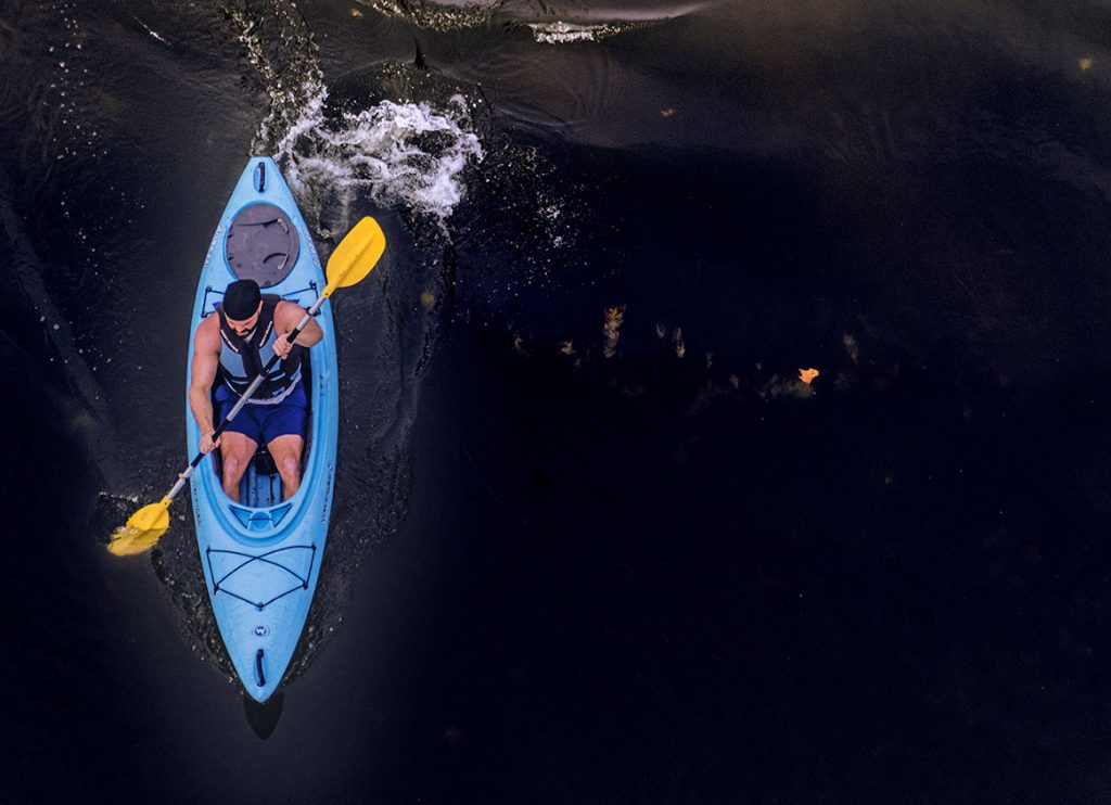 blue kayak is paddled by male down Levisa Fork River