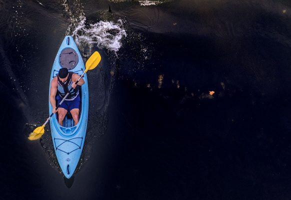 blue kayak is paddled by male down Levisa Fork River